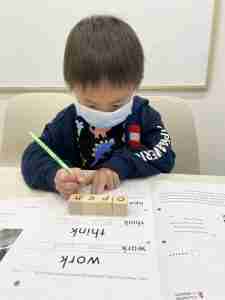 Little boy learning english with wooden block alphabets