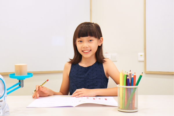 Girl holding a pencil with worksheets